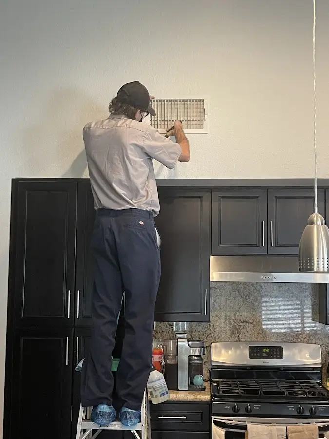 Technician inspecting an air vent during HVAC service in Upper Southampton